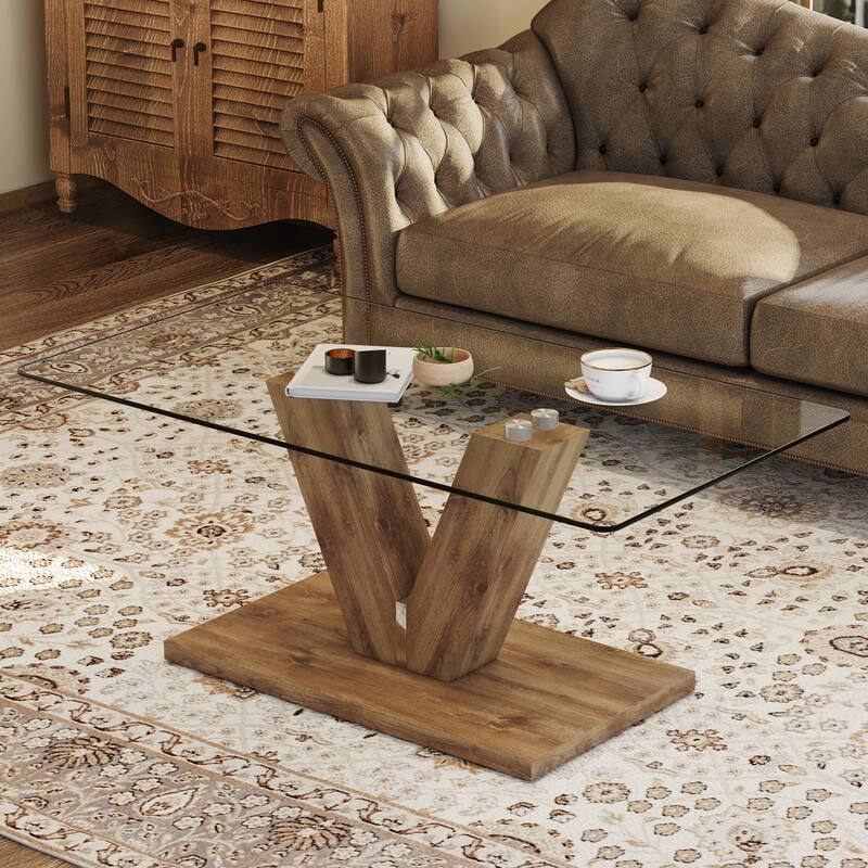 A modern minimalist style coffee table. Transparent tempered glass tabletop with wooden MDF columns