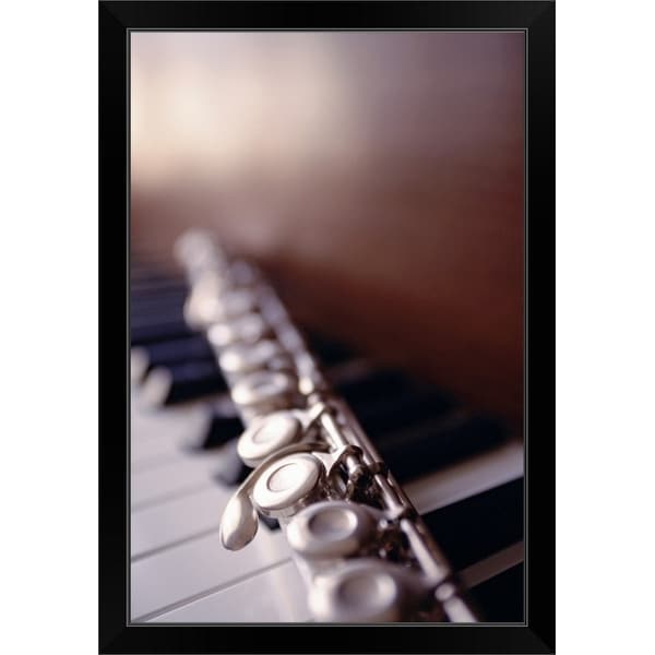 "Close-up of flute on piano keys" Black Framed Print