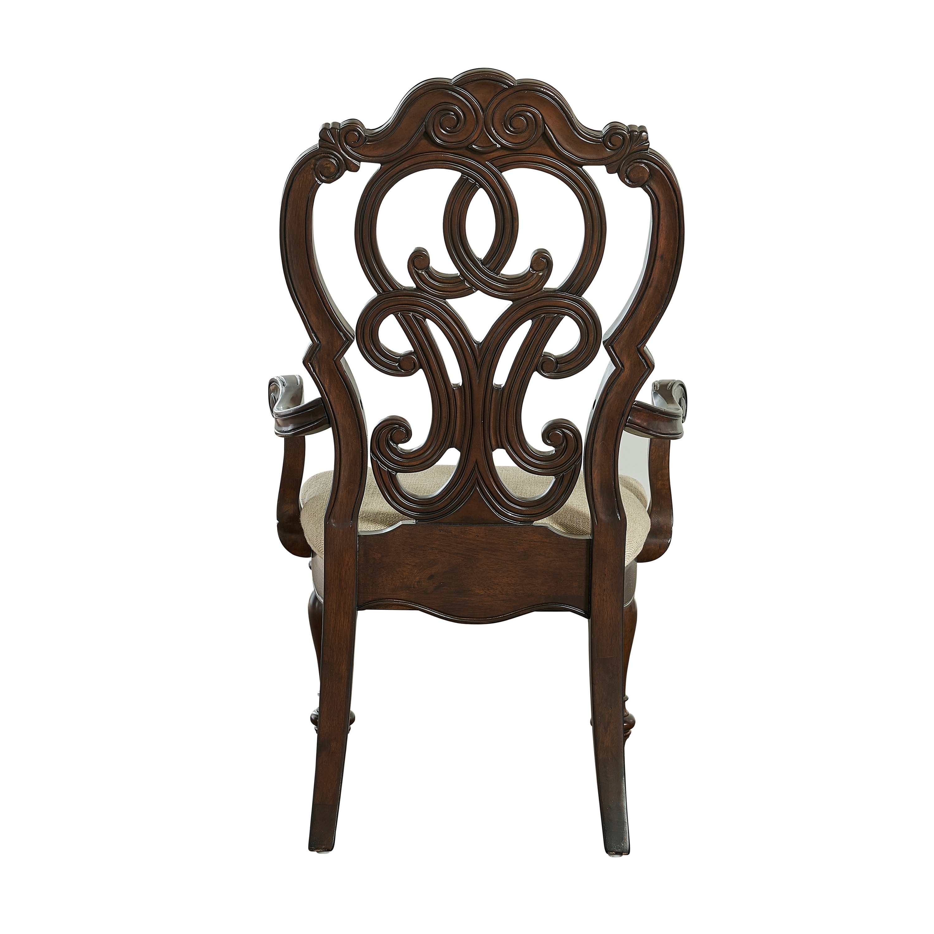 Two matching dark wood ornate chairs with carved backs and cushioned beige seats placed on a patterned rug in a room.