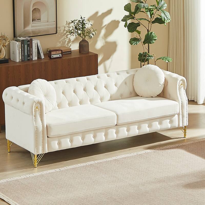 Chesterfield Sofa with Two Round Pillows, Featuring Copper Stud Detailing and Tufted Button Accents - Beige