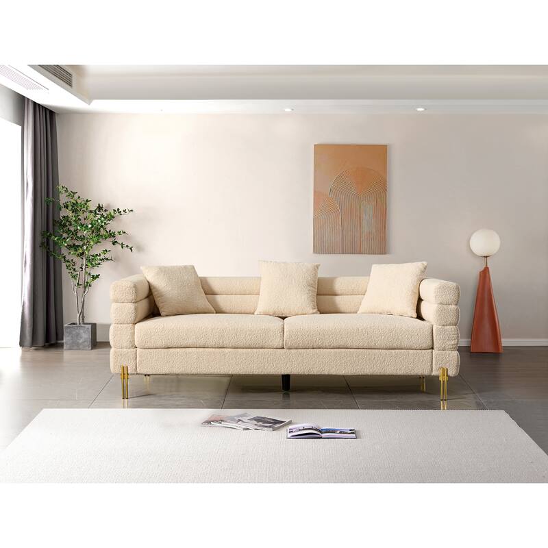 Luxurious and comfortable upholstered sofa with golden legs and pillows for living room and reception area