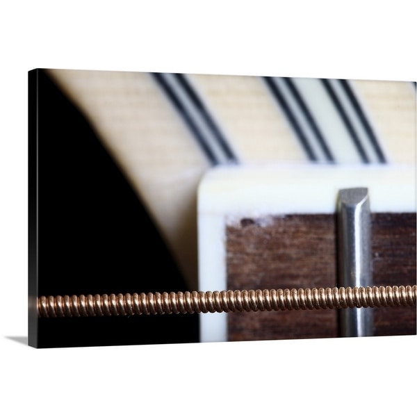 "Macro shot of sixth string of acoustic guitar showing part of fretboard." Canvas Wall Art