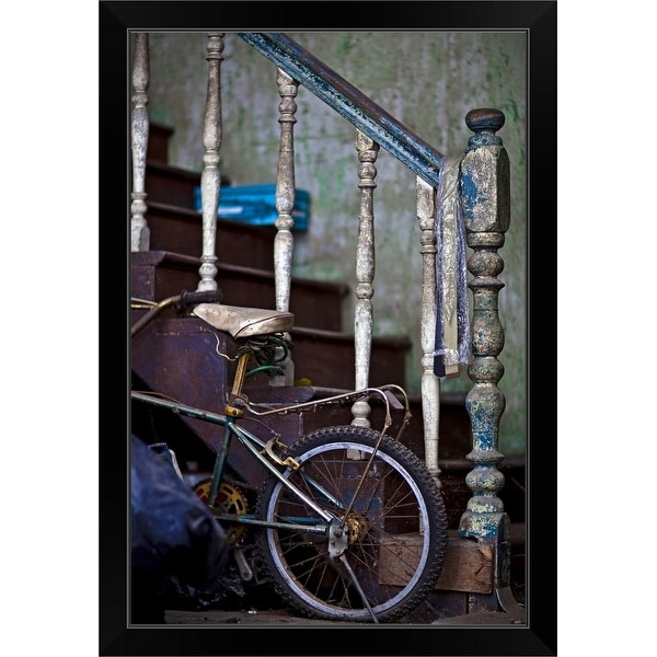 "an old staircase with paint peeling provides support for a childs bicycle" Black Framed Print
