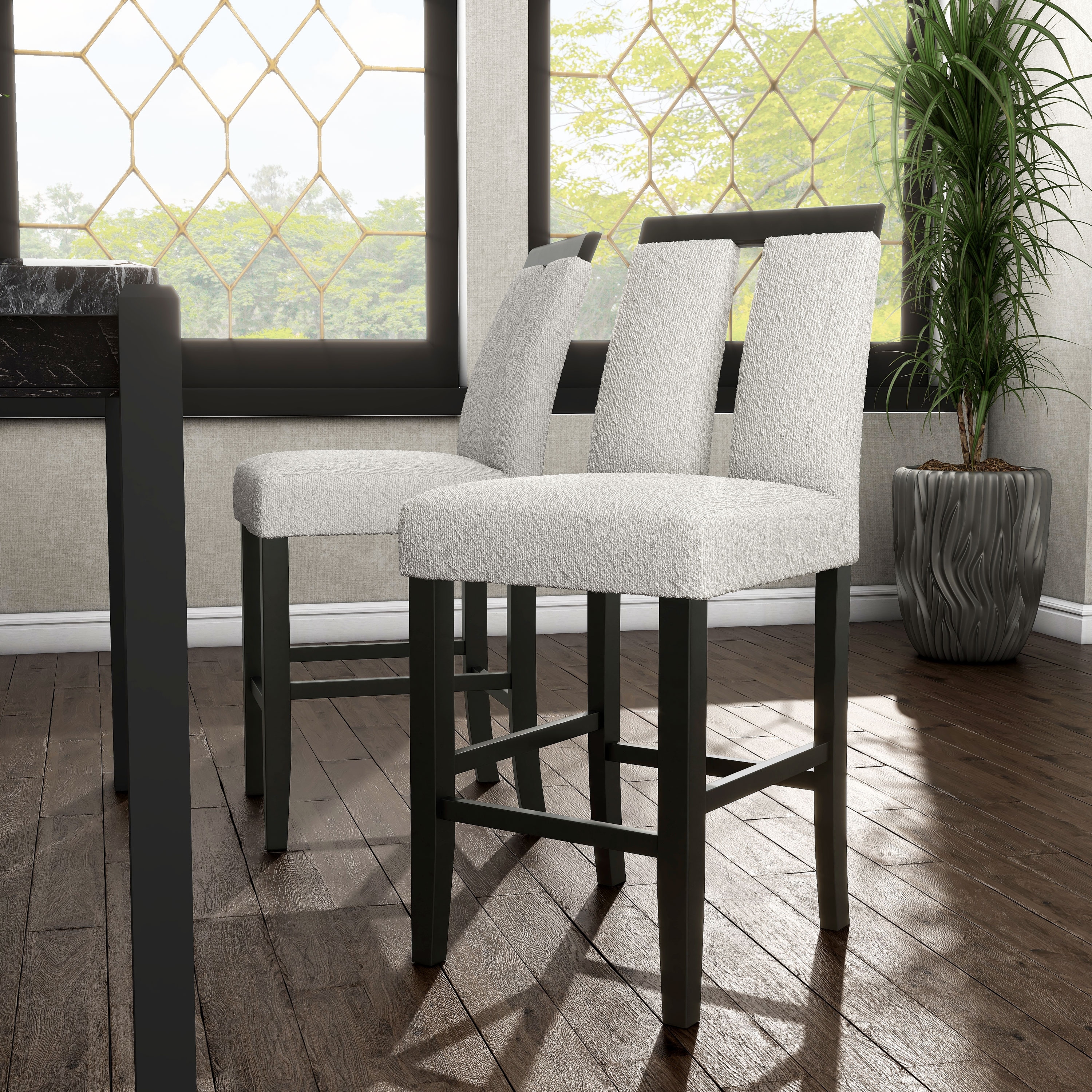 Counter-height dining chairs placed near a large window with greenery.