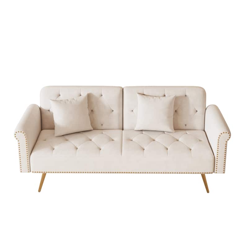 A 69.7-inch-long sofa bed covered in beige velvet fabric, featuring nail head trim and accompanied by a matching throw pillow