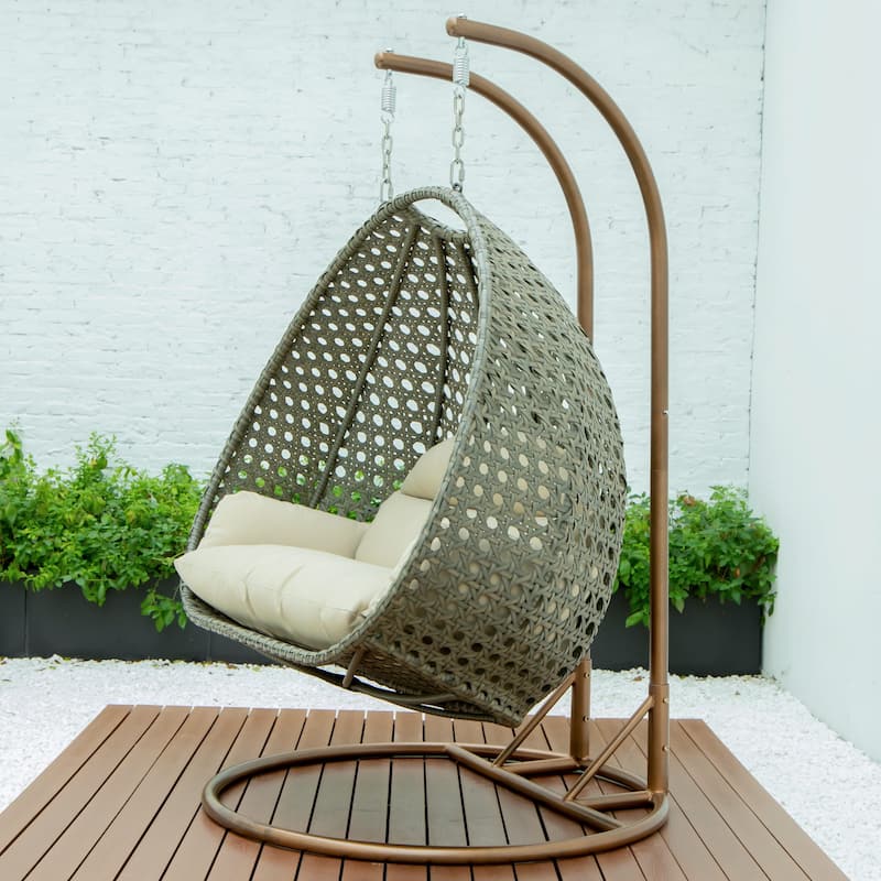 LeisureMod 2-Person Hanging Egg Swing Chair with Metal Stand - Handcrafted Beige Wicker, Patio Hammock Lounger with Cushions