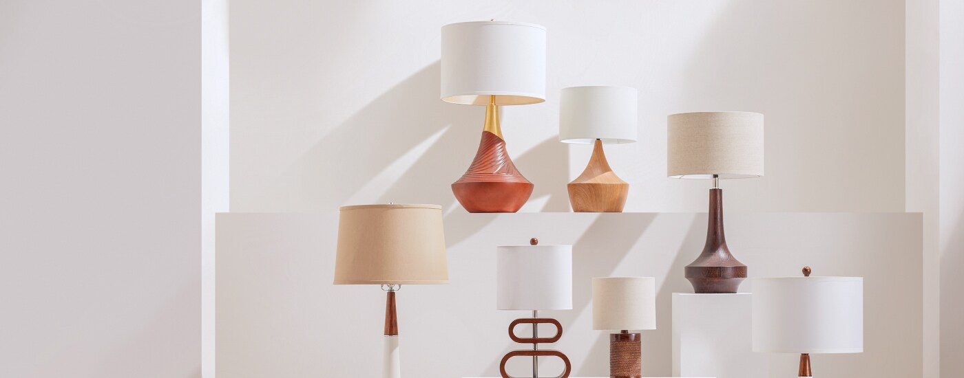 Several table lamps displayed in front of a blank wall with natural lighting available online at Overstock