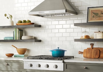 Stainless steel range hood in a modern farmhouse kitchen