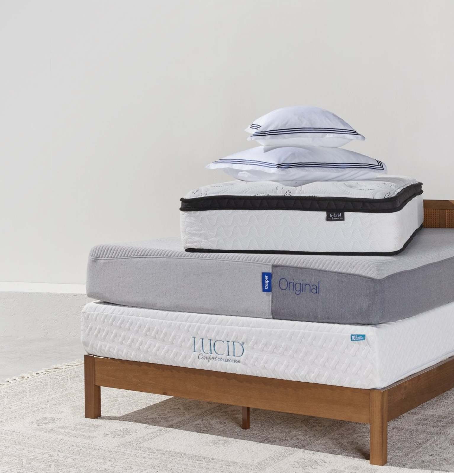 A Lucid stack of Lucid brand mattresses on a bed wooden mattress frame available online at Overstock.
