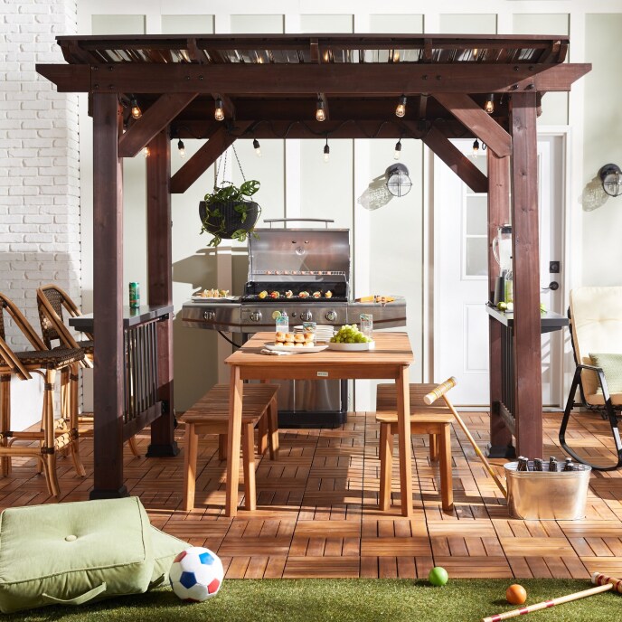 an outdoor dining set and grill beside various lawn games