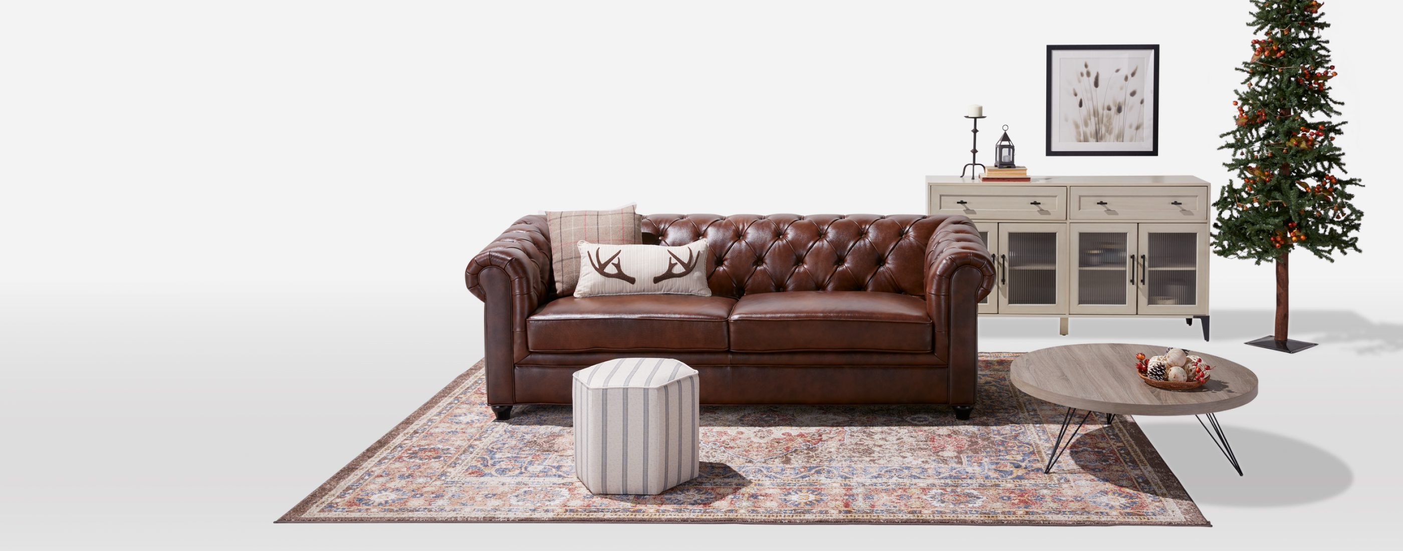 a brown leather sofa with holiday accent pillows on a large rug with other living room furnishings available online at Overstock