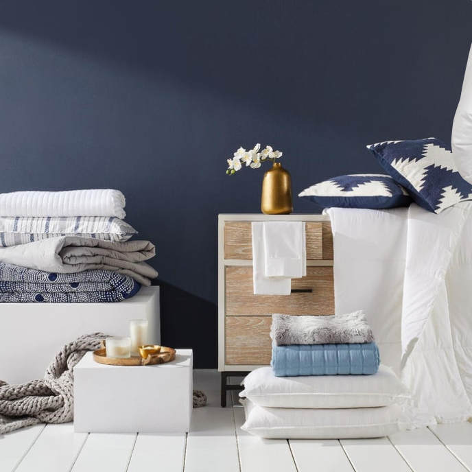 A showcase of white and blue bath towels and bedsheets available online at Overstock.