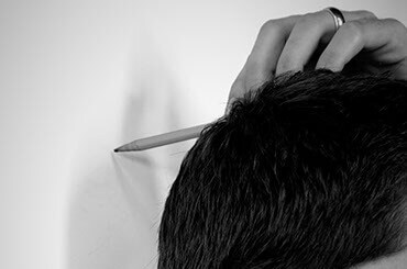Man marking height against wall with a pencil