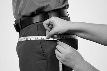 Side view of man in dress clothes having his seat measured