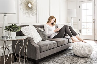 Provide Additional Comfort and Quiet Woman sitting on gray couch reading