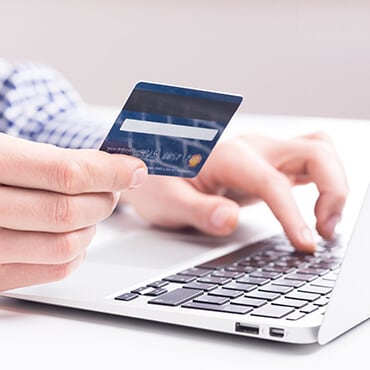 Save More with Store Credit Cards Man making an online purchase on his credit card