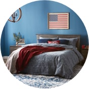 Bedroom with an American flag on the wall and a bed with red, white, and blue blankets