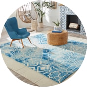 Beach house living room with a blue armchair beside an accent table on a blue rug