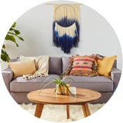 Living room with a gray sofa, a wooden coffee table, a faux fur rug, and decor in eclectic patterns