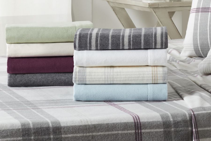 Stacks of fleece sheets on a made bed