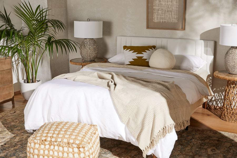 White and beige bedroom with a plant and wicker furniture