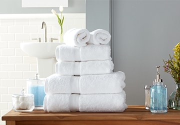 Stack of plush white body towels, hand towels, and face towels