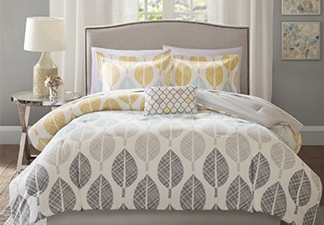 Blankets, pillows, sheets, and other bedding with gray and yellow leaf patterns