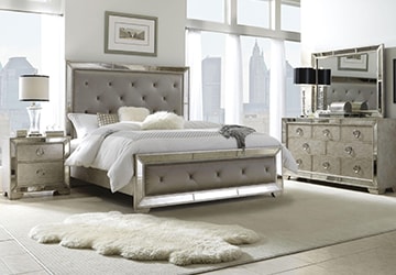 Bedroom set including a dresser, a nightstand, a bed, bedding, and a rug