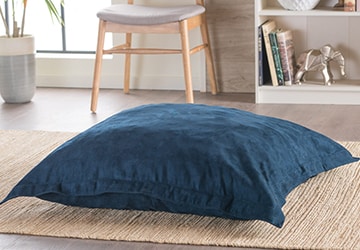 Oversized pillow centered on a jute rug in a kid’s room