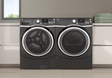 Matching black washer and dryer in a white laundry room