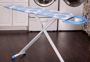 Ironing board set up in a laundry room