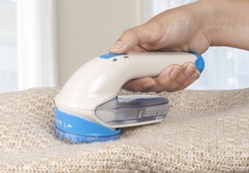 Lint shaver being used on a knit sweater