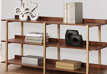 Wooden bookshelves holding books, sculptures, and accent boxes