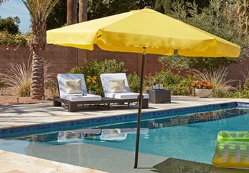 Yellow patio umbrella next to a swimming pool