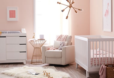 Pink nursery with a white crib, a dresser, and a comfortable chair