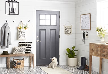 Orderly entryway with coat hooks, a wooden bench, and a white runner rug